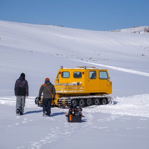 a man riding a snowboard down a snow covered slope