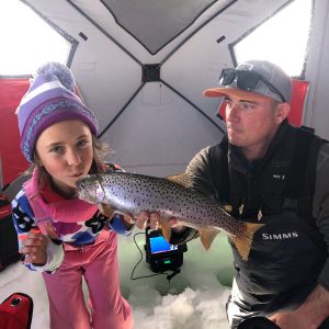 a man holding a fish in the snow